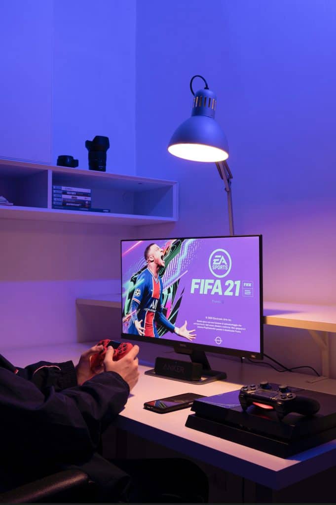 playing FIFA 21 with PS4 controller in hand